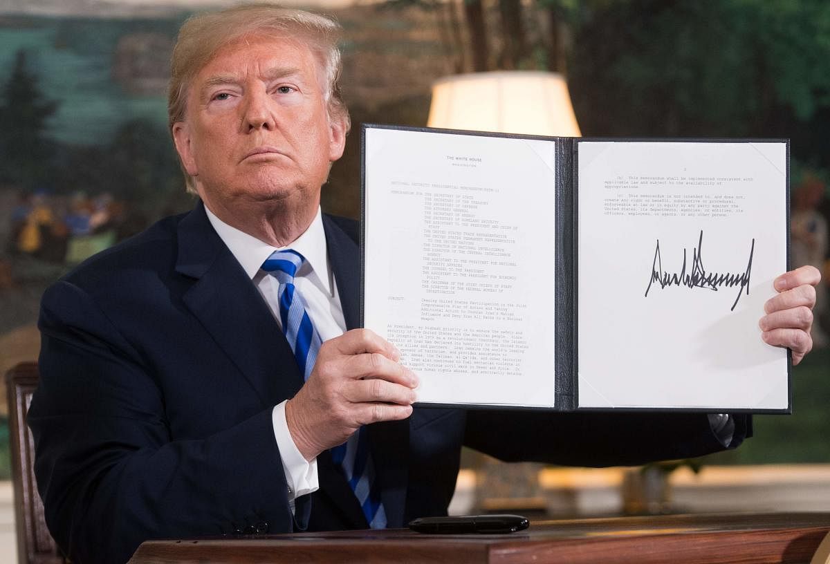 In this file photo taken on May 08, 2018 US President Donald Trump signs a document reinstating sanctions against Iran after announcing the US withdrawal from the Iran Nuclear deal, in the Diplomatic Reception Room at the White House in Washington, DC. AF