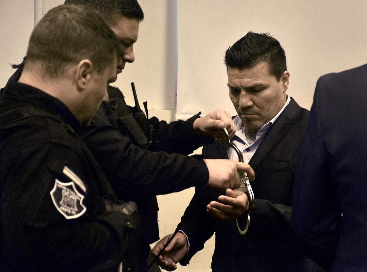 In this handout photo released by Telam, Argentine former boxer Carlos Baldomir (R) have his handcuffs removed at a court in Santa Fe, Argentina on July 31, 2019. (AFP PHOTO / TELAM / EL LITORAL / Guillermo SALVATORE)