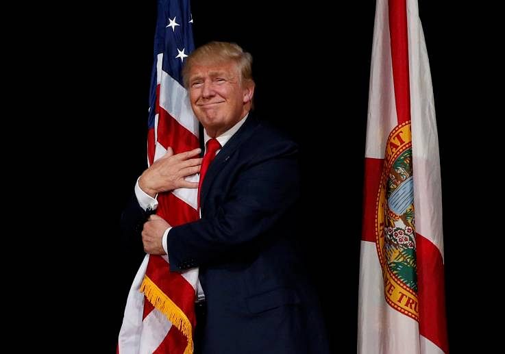 In picture: U.S. President Donald Trump hugging the American flag. Reuters/JONATHAN ERNST photo 