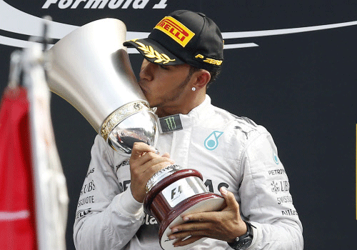 Mercedes driver Lewis Hamilton, of Britain, kisses the trophy as he celebrates on the podium after winning the Italian Formula One Grand Prix at the Monza racetrack, in Monza, Italy, Sunday, Sept. 7, 2014. AP Photo