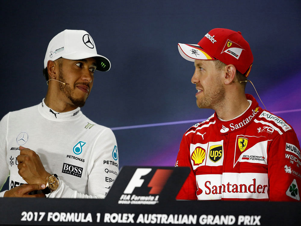 Ferrari driver Sebastian Vettel of Germany (R) speaks with second-placed Mercedes driver Lewis Hamilton of Britain at the post-race press conference. Reuters photo