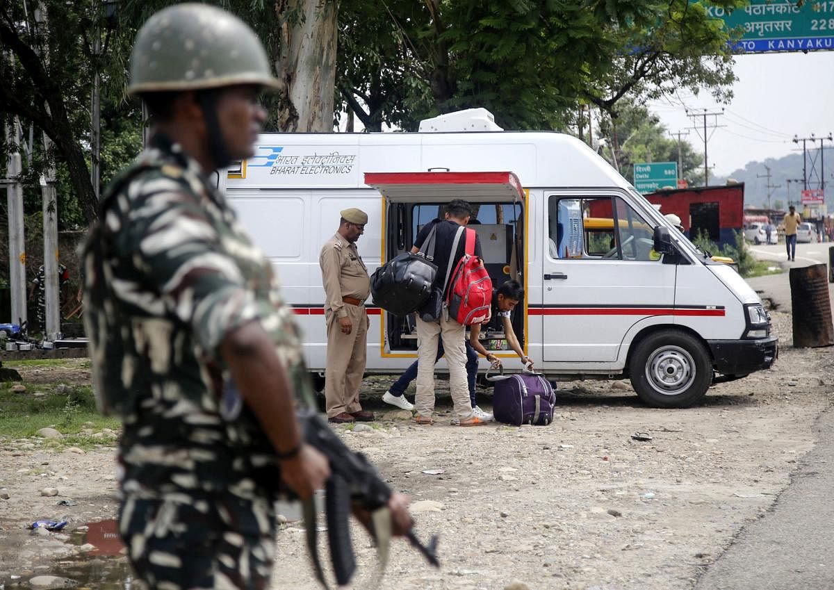 An Indian security forces personnel stands guard as Jammu Kashmir policemen check the luggage and vehicles of commuters on the Jammu-Srinagar National Highway at Nagrota some 25 kms from Jammu. AFP file photo