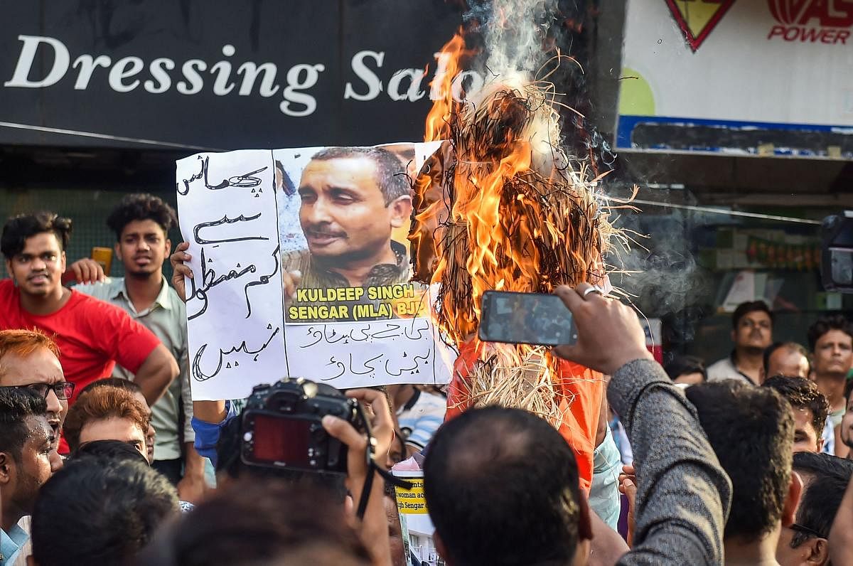 Youth Congress workers burn an effigy of UP Chief Minister Yoga Adityanath, as they display posters of main accused BJP MP Kuldeep Singh Sengar, near State BJP office in protest over Unnao rape incident in Kolkata. PTI photo