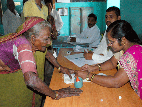 A 100 year old woman cast her vote for the Assembly elections at a polling booth in Karad on Wednesday. PTI Photo