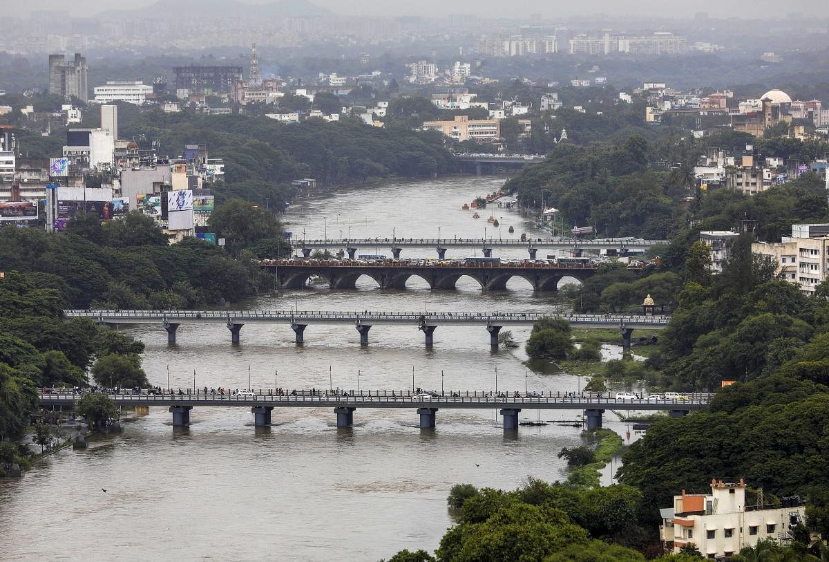 A view of the Mutha River flooded with rain and water released from Khadakwasla Dam, in Pune on Tuesday. PTI
