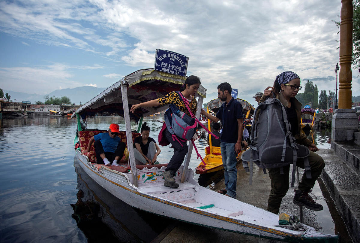 Foreign tourists disembark from a boat on the banks of Dal Lake as they prepare to leave Srinagar (Reuters Photo)