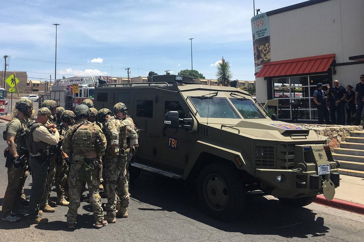 Armed Policemen gather next to an FBI armoured vehicle next to the Cielo Vista Mall as an active shooter situation is going inside the Mall in El Paso on August 03, 2019. AFP