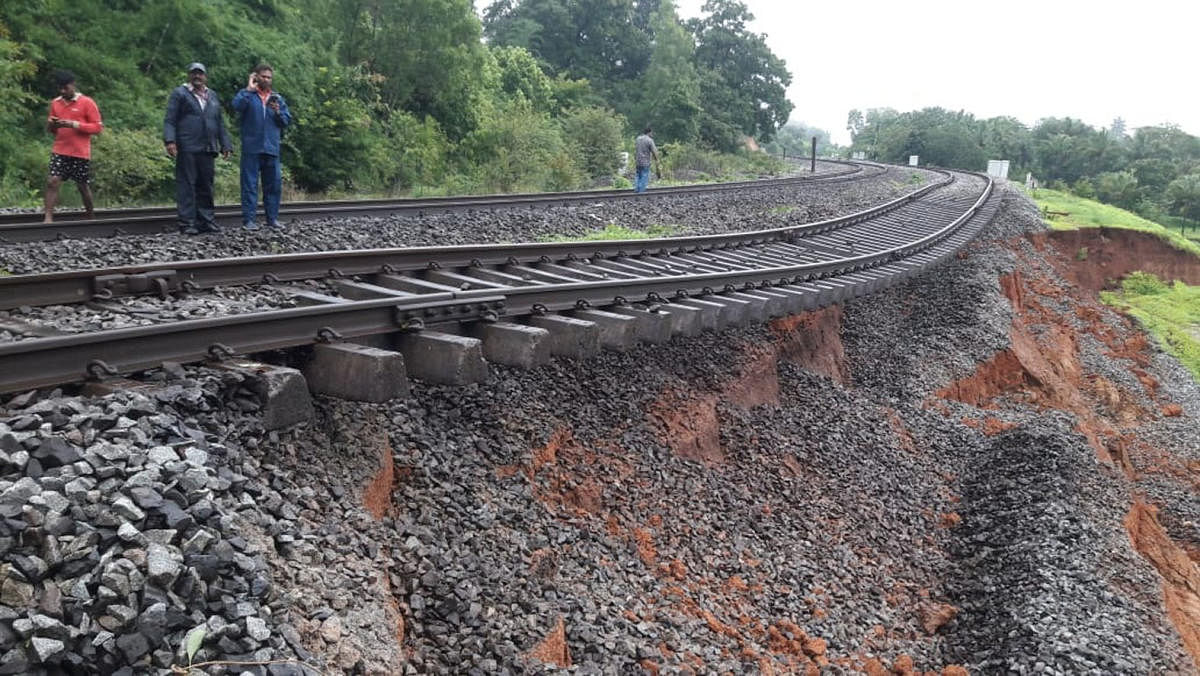 The soil bed beneath the rail tracks at Tinaighat section near Londa in Khanapur district of Belagavi is washed away due to heavy rain, affecting train movement. DH Photo