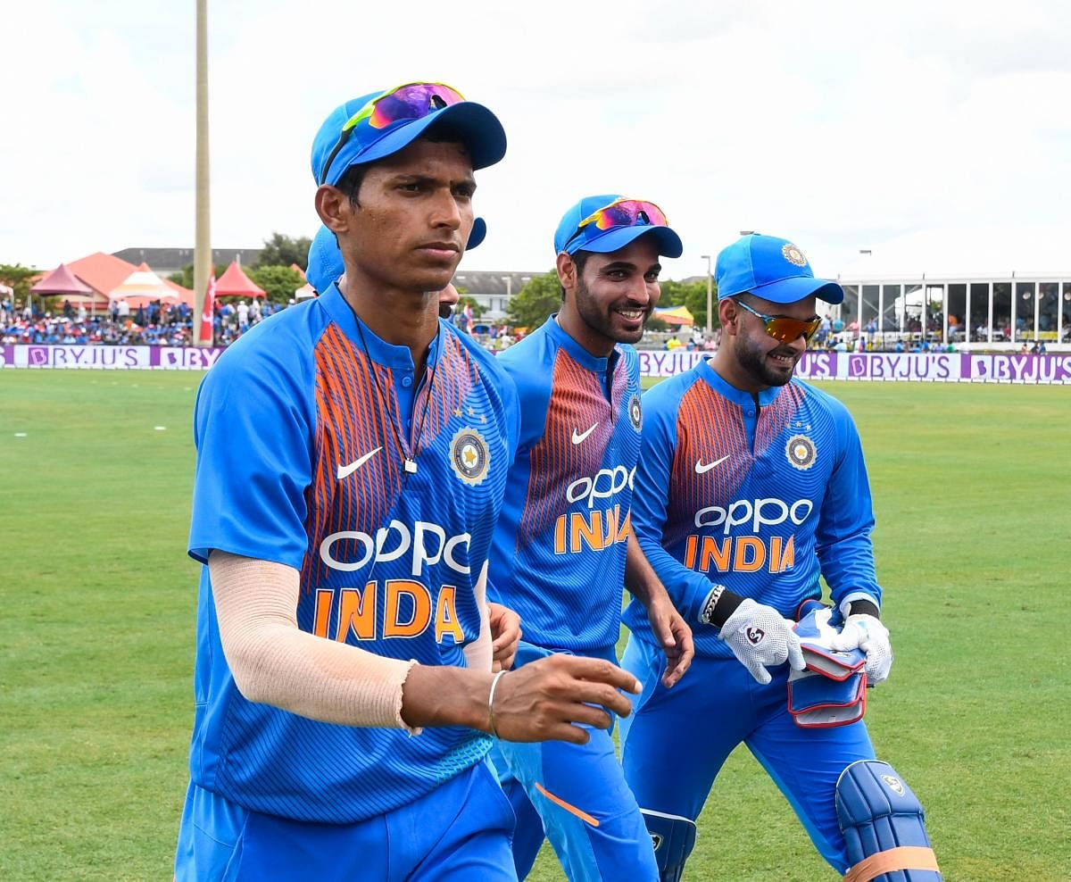Navdeep Saini (L), Bhuvneshwar Kumar (C) and Rishabh Pant (R) of India walks off the field during the 1st T20i match between West Indies and India at Central Broward Regional Park Stadium in Fort Lauderdale, Florida, on August 3, 2019. (Photo by Randy Bro