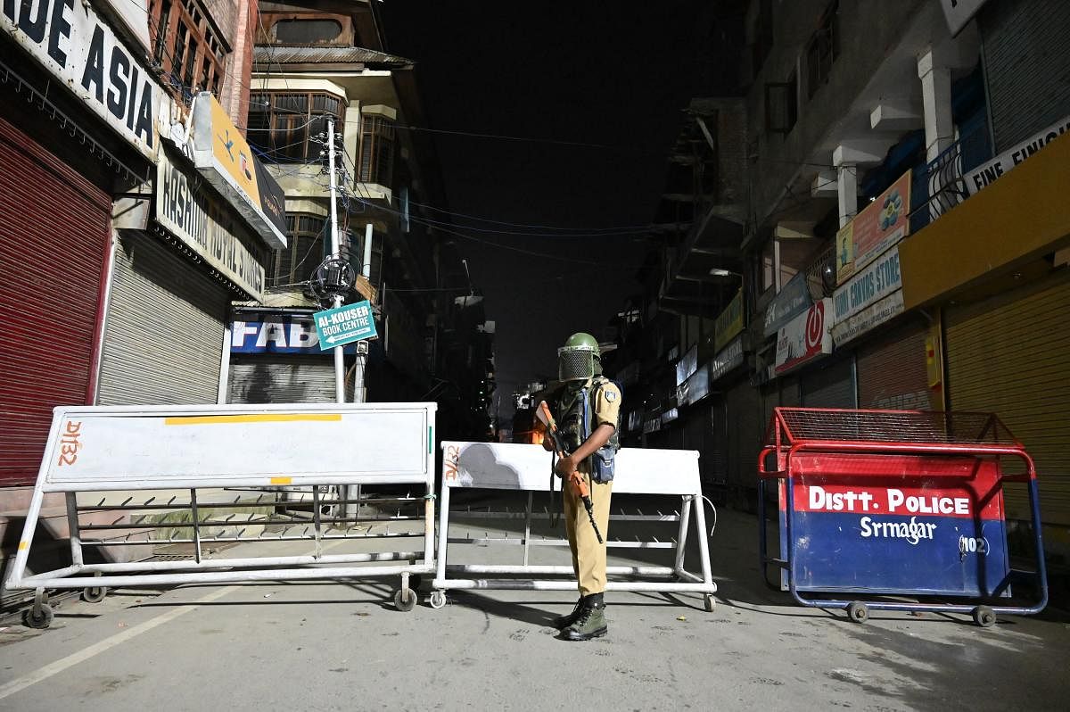 An Indian paramilitary trooper stands guard at a roadblock at Maisuma locality in Srinagar (AFP Photo)