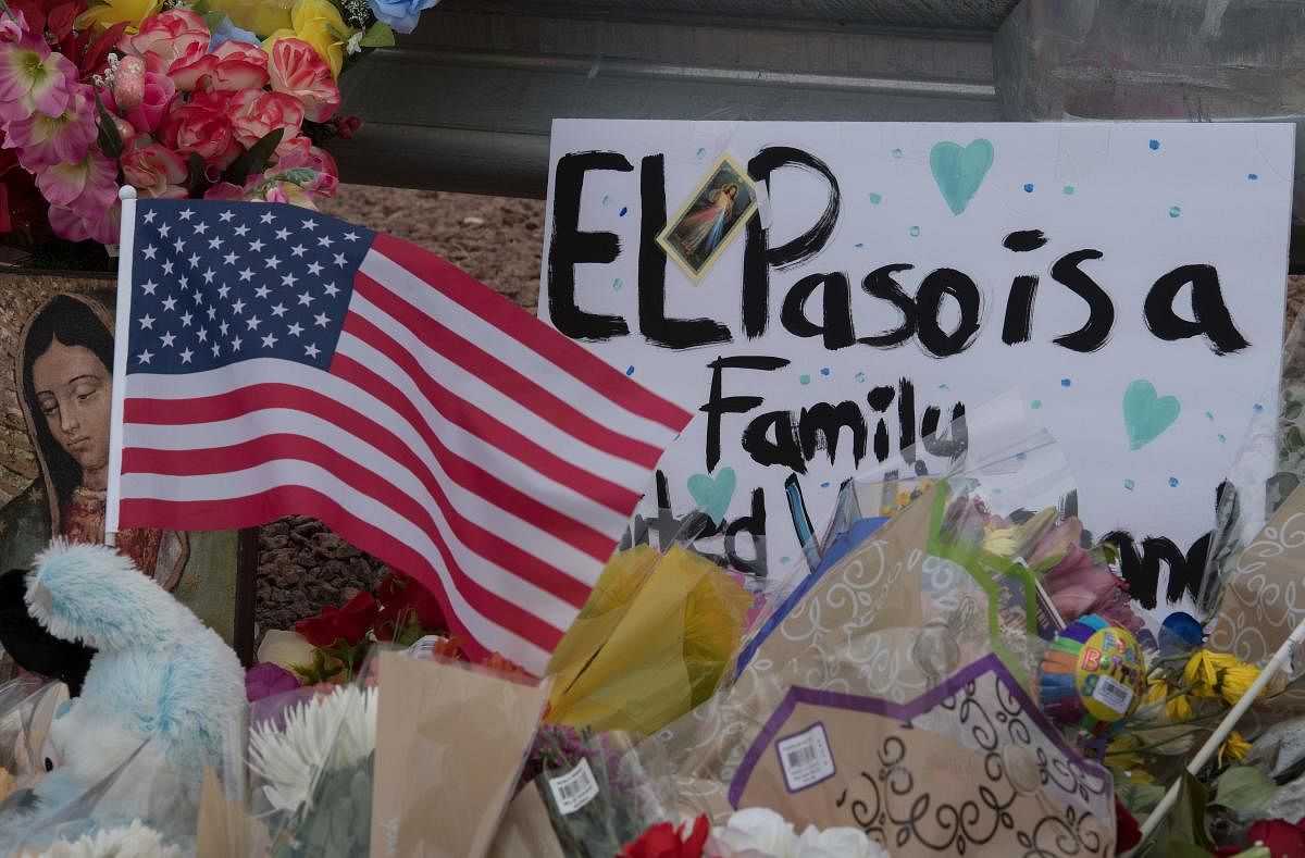 The US flag and flowers at a makeshift memorial outside the Cielo Vista Mall Wal-Mart (background) where a shooting left 20 people dead in El Paso, Texas, on August 4, 2019. (AFP)