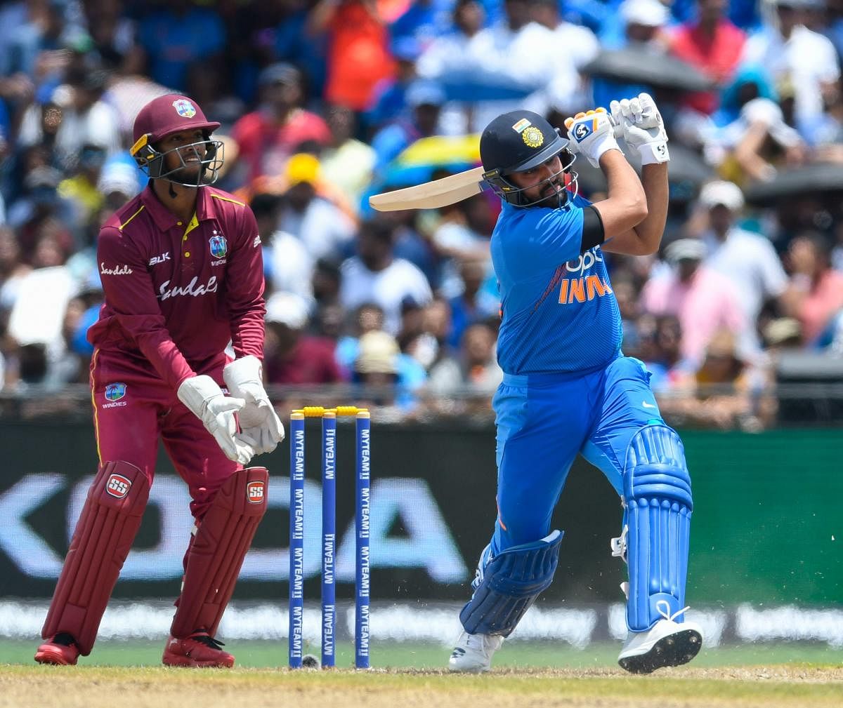 Rohit Sharma (R) of India hits 4 as Nicholas Pooran (L) of West Indies looks on during the 1st T20i match between West Indies and India at Central Broward Regional Park Stadium in Fort Lauderdale, Florida, on August 3, 2019. (Photo by Randy Brooks / AFP)