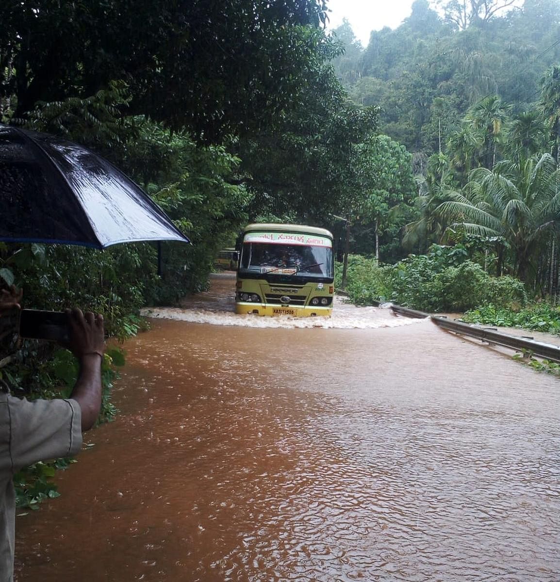 A KSRTC bus struggles to navigate through a flooded road near Katagala in Kumta taluk of Uttara Kannada district on Monday.