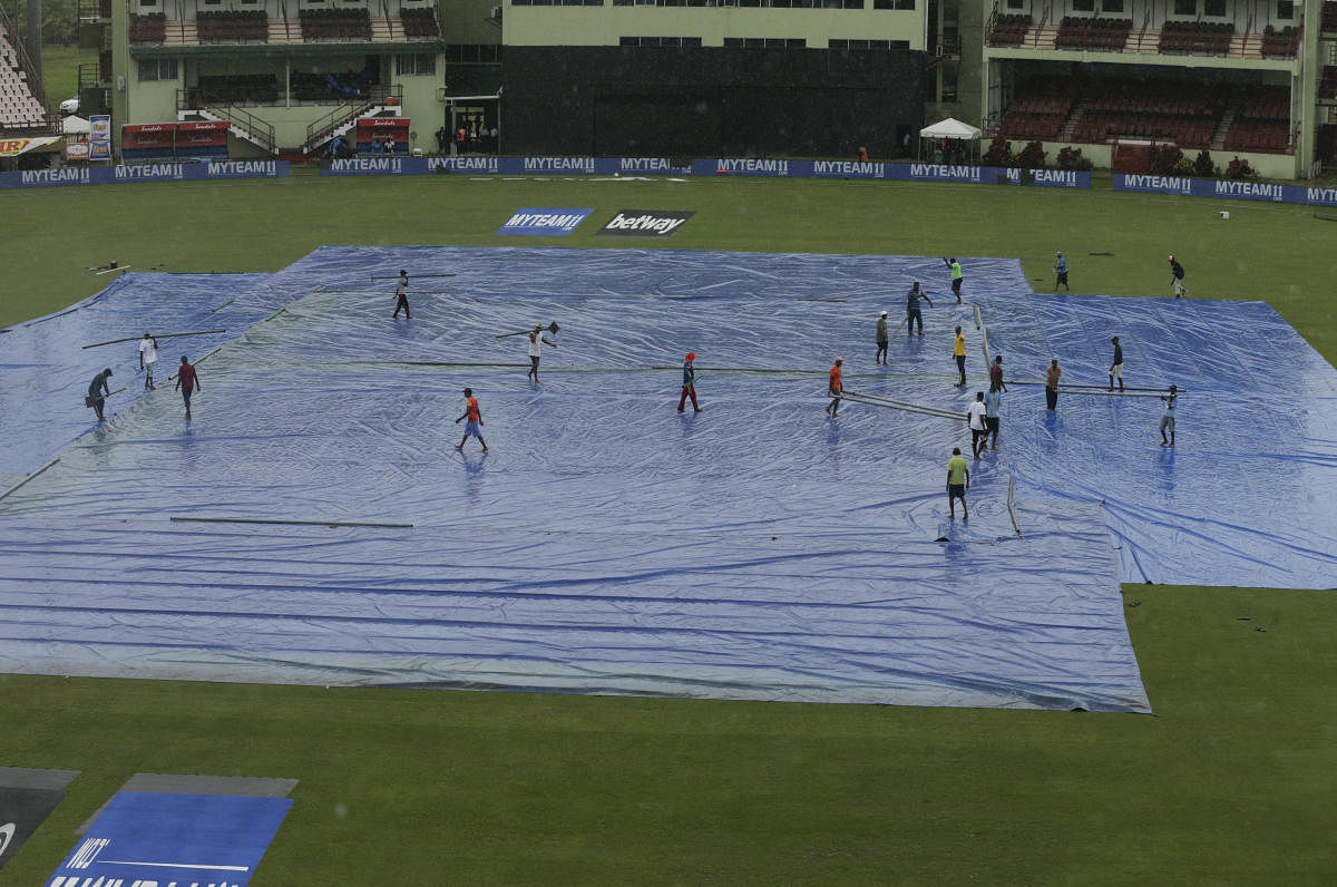 he pitch of the National Stadium is covered by the tarp as rain falls prior the India and West Indies third T20 international cricket match in Providence, Guyana. AP Photo