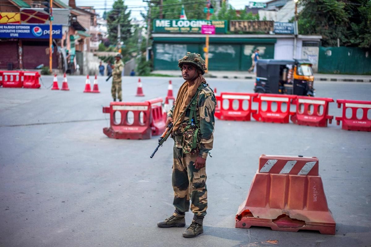 Security personnel stand guard on a street in Srinagar. (AFP Photo/Vikar Syed)