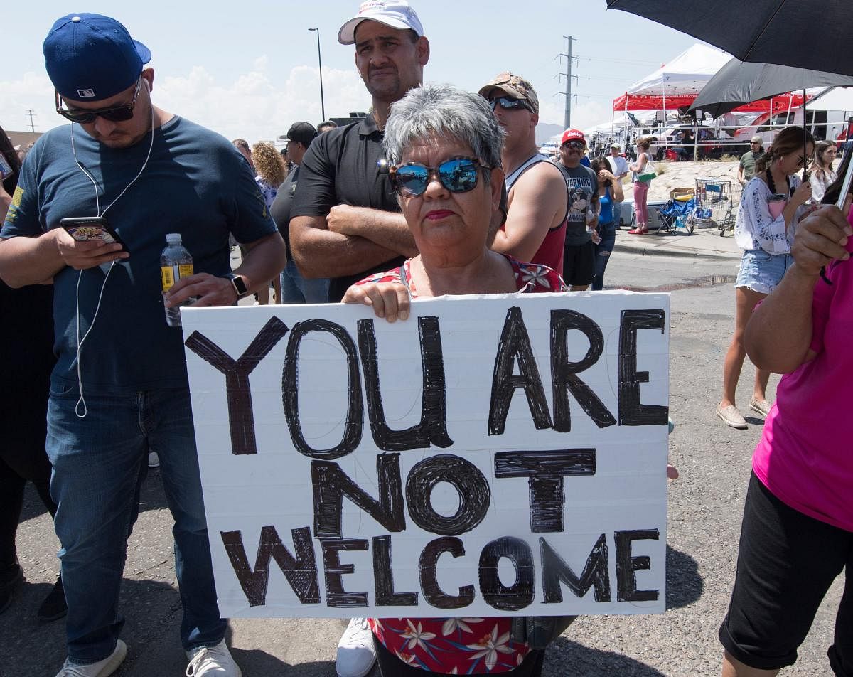  Anti-Trump protesters hold signs outside the makeshift memorial to the victims of the WalMart shooting that left a total of 22 people dead, in El Paso, Texas, on August 7, 2019. (AFP)