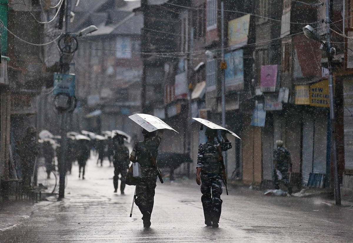 Security personnel walk on a street in Srinagar. AFP photo