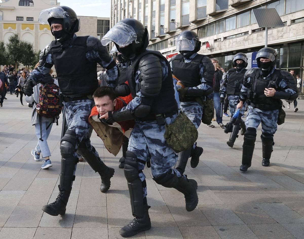 Police officers detain a protestor, during an unsanctioned rally in the center of Moscow. PTI Photo