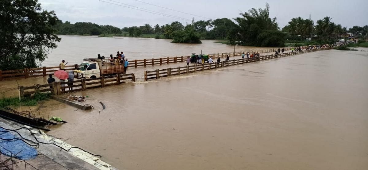 The bridge connecting Halagi and Marol villages in Haveri district has been submerged in swollen Varadha river.