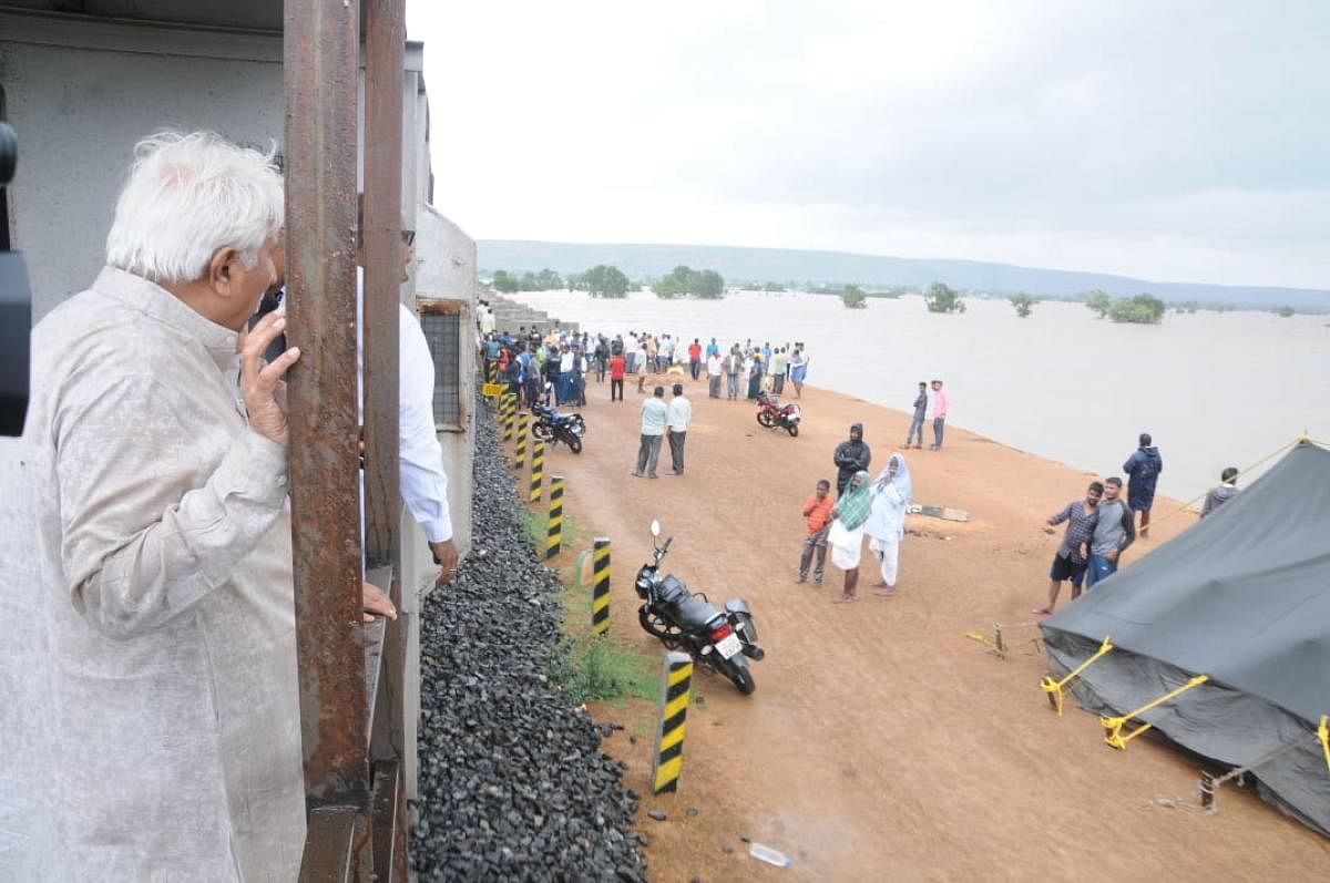 MLA H K Patil surveys the rain damage on the banks of the Malaprabha river which is spate standing inside the guard van of a goods train. He was part of a KPCC team that surveyed the flood situation in north Karnataka on Friday.