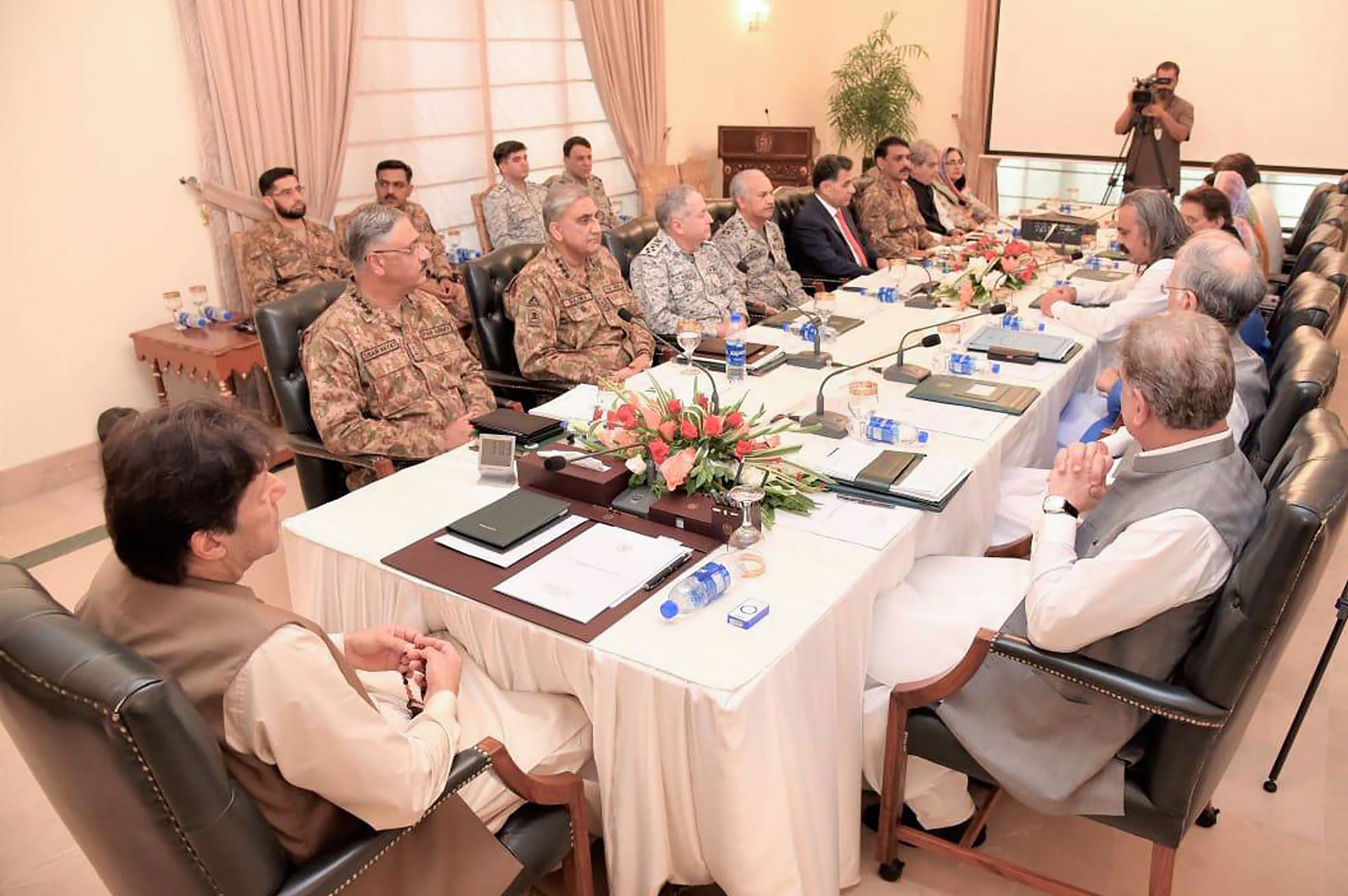  Pakistan Prime Minister Imran Khan (L) chairs the National Security Committee meeting in Islamabad. - Fears of an impending curfew in the disputed region of Kashmir ratcheted up tensions. (AFP Photo)