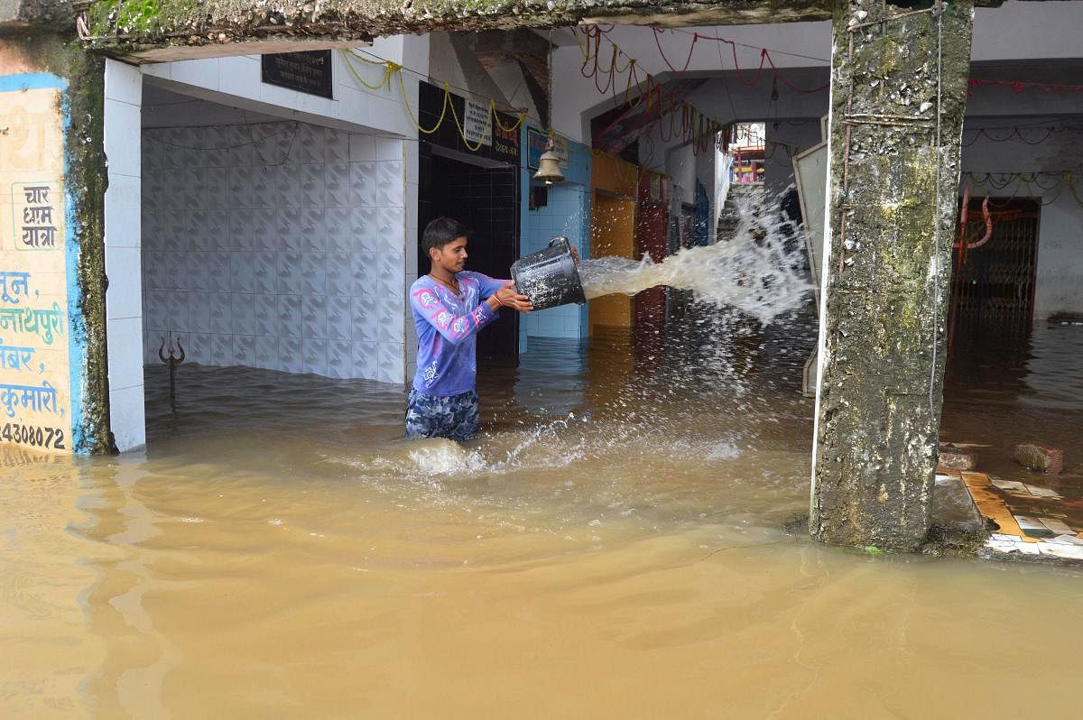  A man attempts to drain floodwater from temple following heavy monsoon rain, in Jabalpur. PTI photo