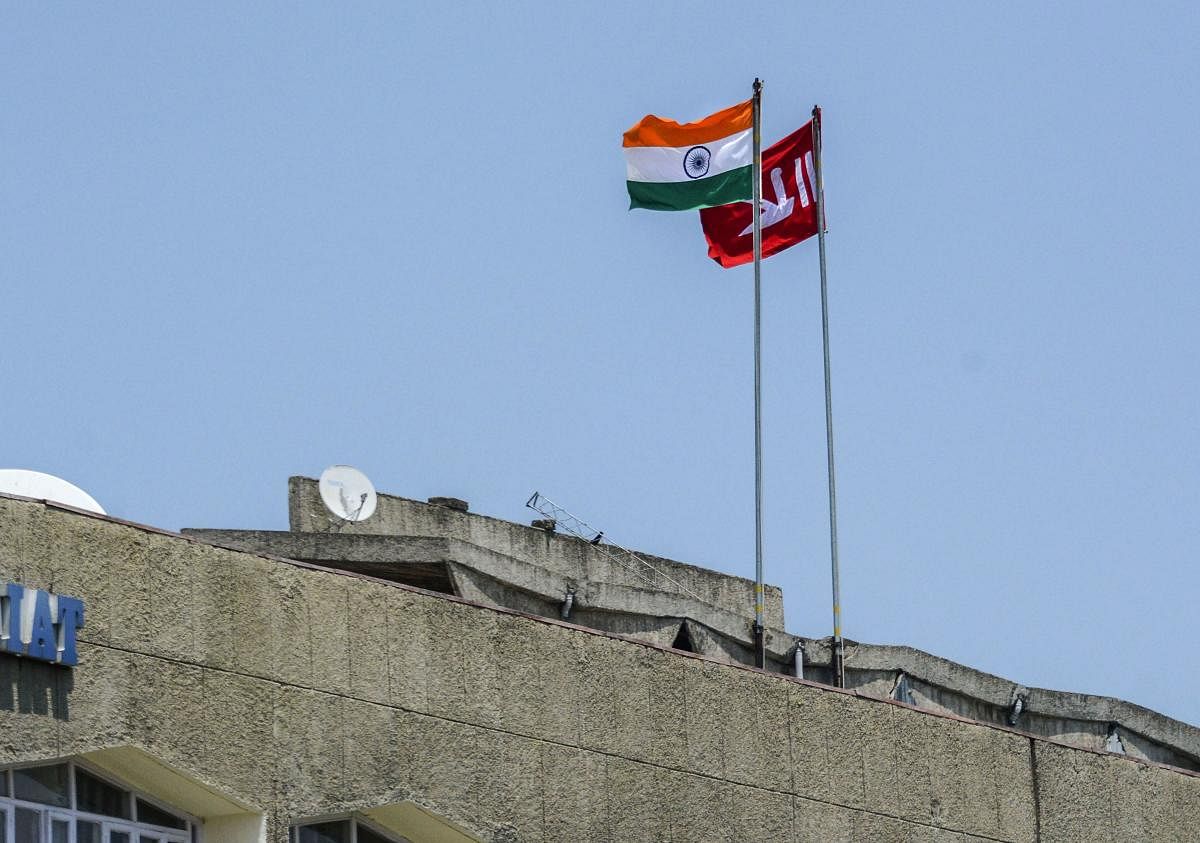 Indian national flag and Jammu and Kashmir state flag stand hoisted at a building during restrictions in Srinagar, Thursday, Aug 8, 2019. (PTI File Photo)