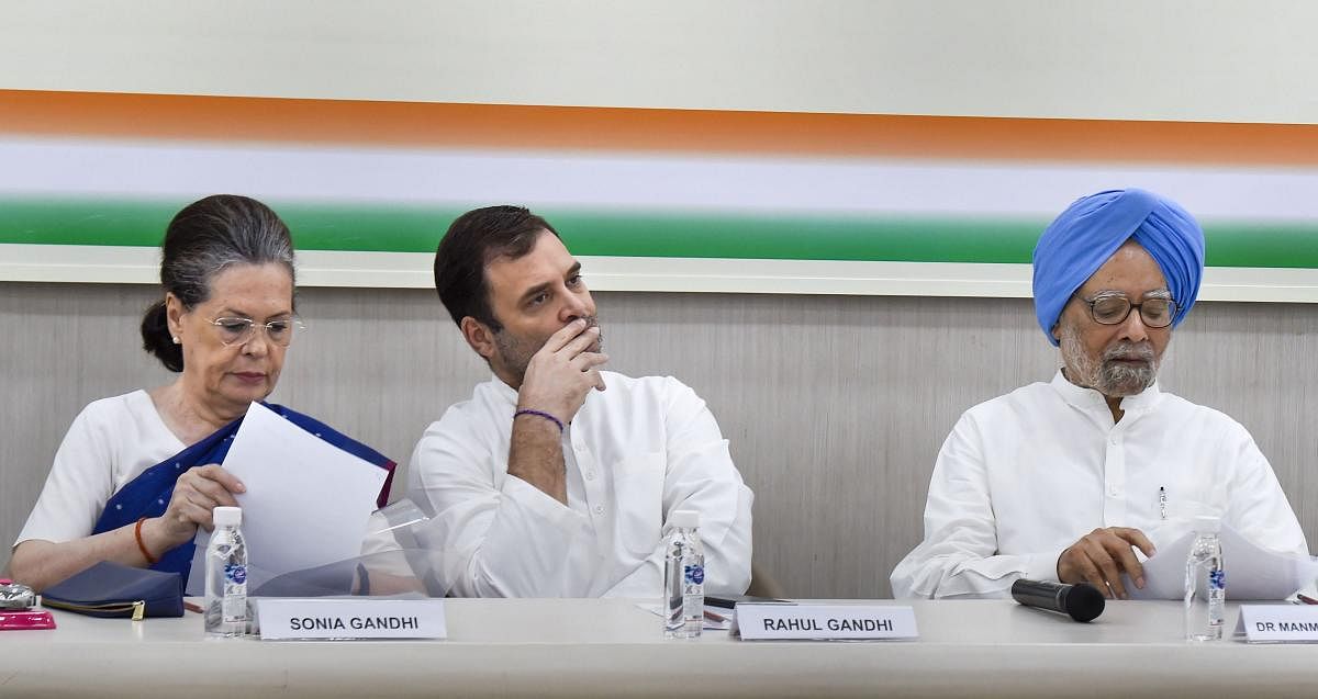 Exiting Congress President Rahul Gandhi flanked by senior party leaders Sonia Gandhi and Manmohan Singh during Congress Working Committee (CWC) meeting, at AICC HQ in New Delhi. (PTI Photo)