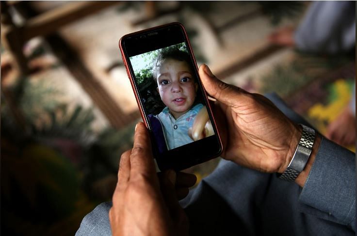 A relative displays the picture of 4-year-old Mohammad Ayan Ali, who, according to his family, was killed after he found a device that looked like a toy and exploded in his hands at home in the village of Jabri, in Neelum Valley, in Pakistan-administrated Kashmir. Pakistan's military says the device was an unexploded cluster bomb.. Picture taken August 9, 2019. REUTERS/Saiyna Bashir