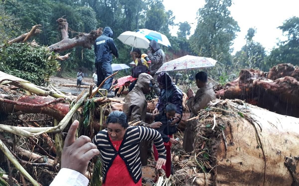 Flood victims on their way to a relief centre at Chennadlu in Mudigere.