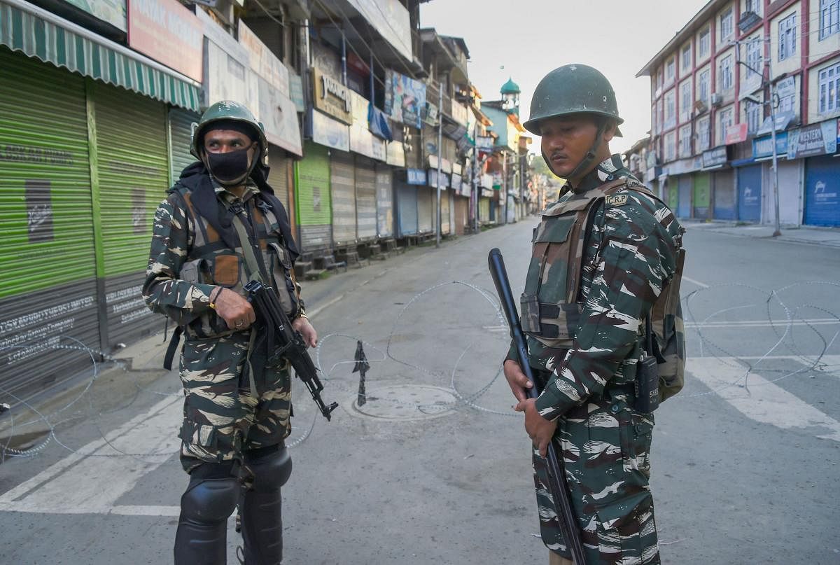 Security personnel stand guard during restriction in Srinagar. (PTI Photo)