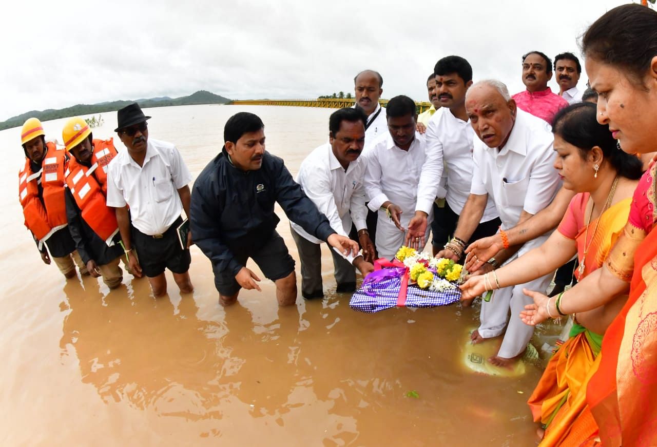 Chief Minister B S Yediyurappa offers bagina at Anjanapura dam in Shikaripur taluk on Tuesday as it reached the maximun level due to incessant rains that lashed the region last week. (DH Photo)