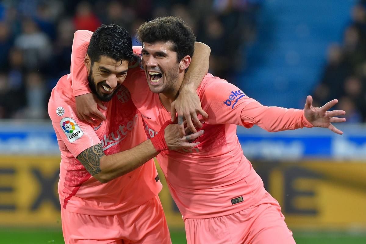 Barcelona's Carles Alena (right) celebrates with Luis Suarez after scoring against Alaves on Tuesday. AFP