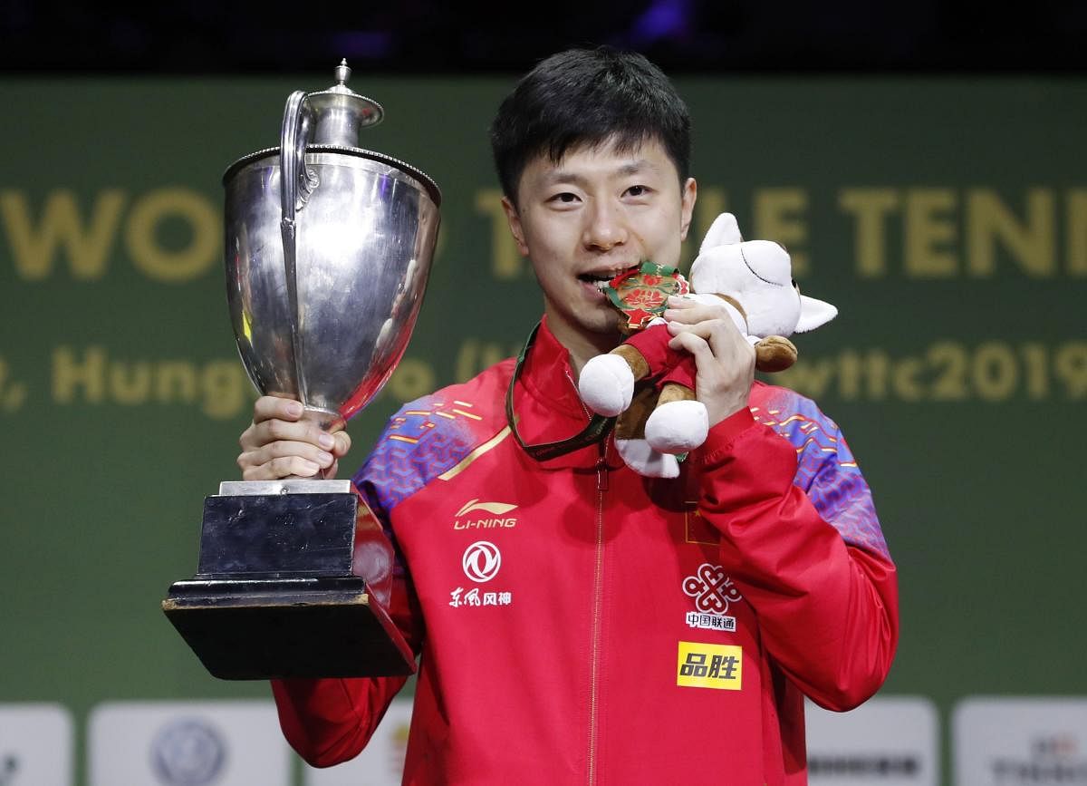 China's Ma Long with the trophy after winning the men's singles title at the World Table Tennis Championships in Budapest on Sunday. REUTERS