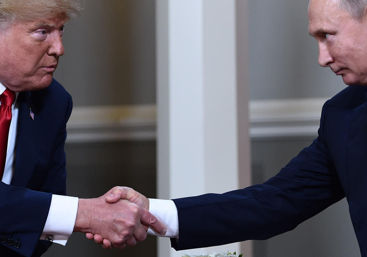 US President Donald Trump (L) and Russian President Vladimir Putin shake hands ahead of a meeting in Helsinki. (Photo by AFP)