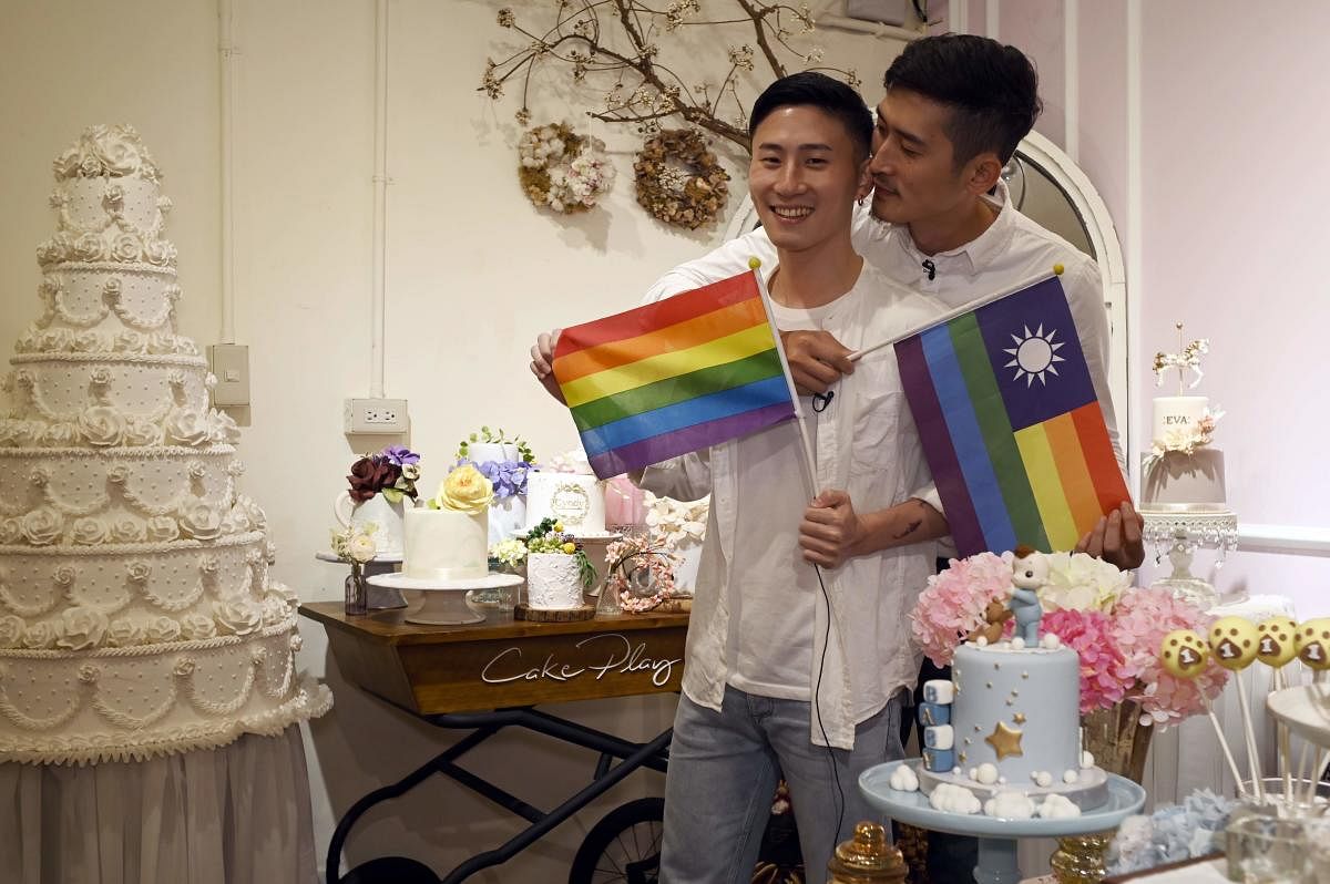 Ccake maker Shane Lin (L) and his lover Marc Yuan posing for a photo during an interview at their workshop Cake Play in Taipei. (Photo by AFP) 