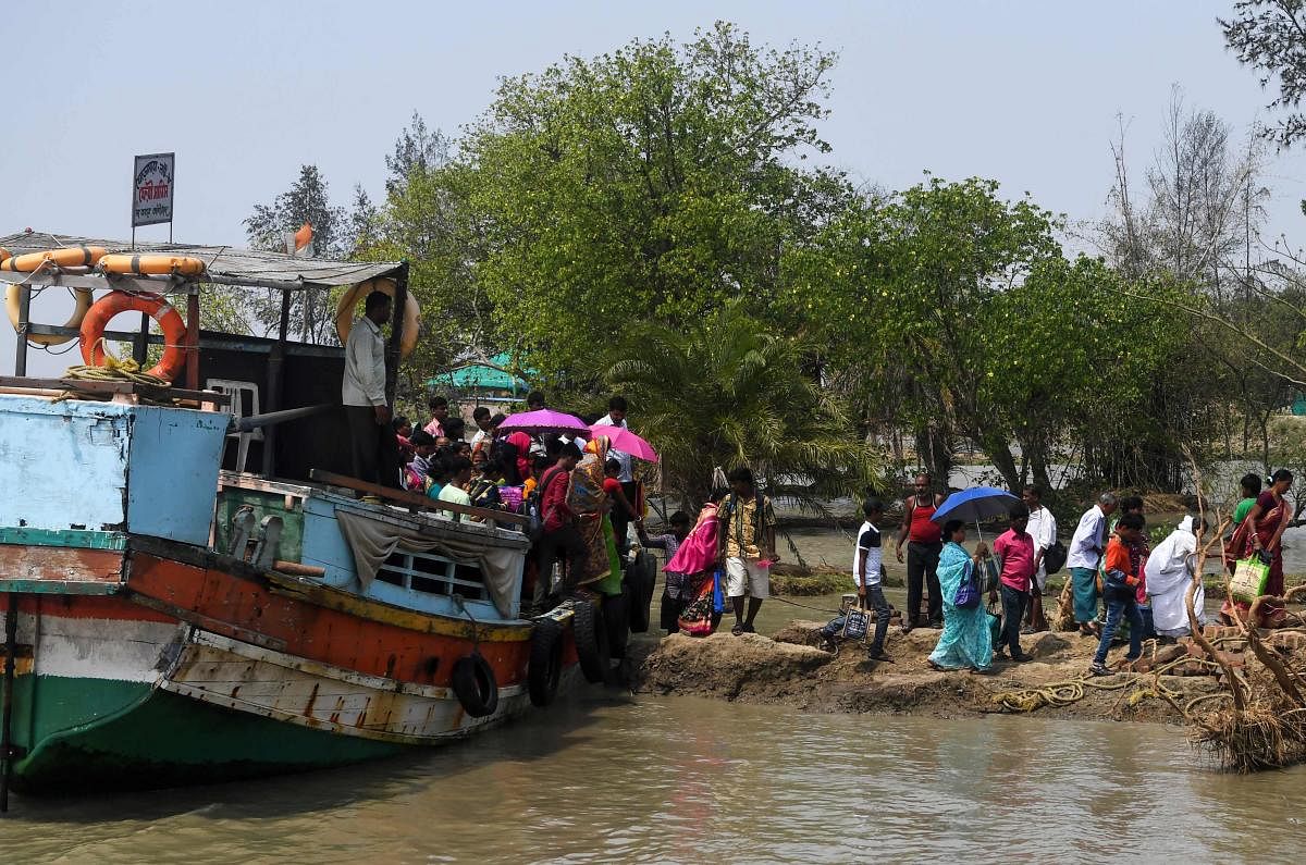 Indian voters arrive with a ferry boat to cast their vote in the Ghoramara island around 110 km south of Kolkata on May 19, 2019, during the 7th and final phase of India's general election. - Voting in one of India's most acrimonious elections in decades