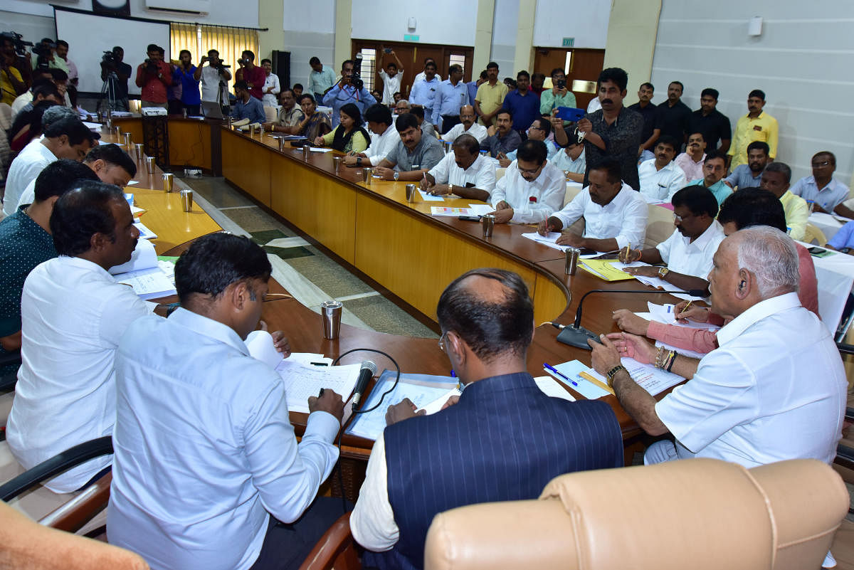 Chief Minister B S Yediyurappa chairs a review meeting after inspecting rain-hit areas, at Dharmasthala on Monday. DH Photo