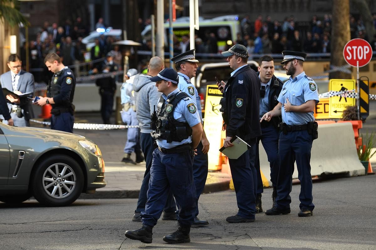 Police gather at the crime scene after a man stabbed a woman and attempted to stab others in central Sydney on August 13, 2019, before being pinned down by members of the public and detained by police. (AFP)