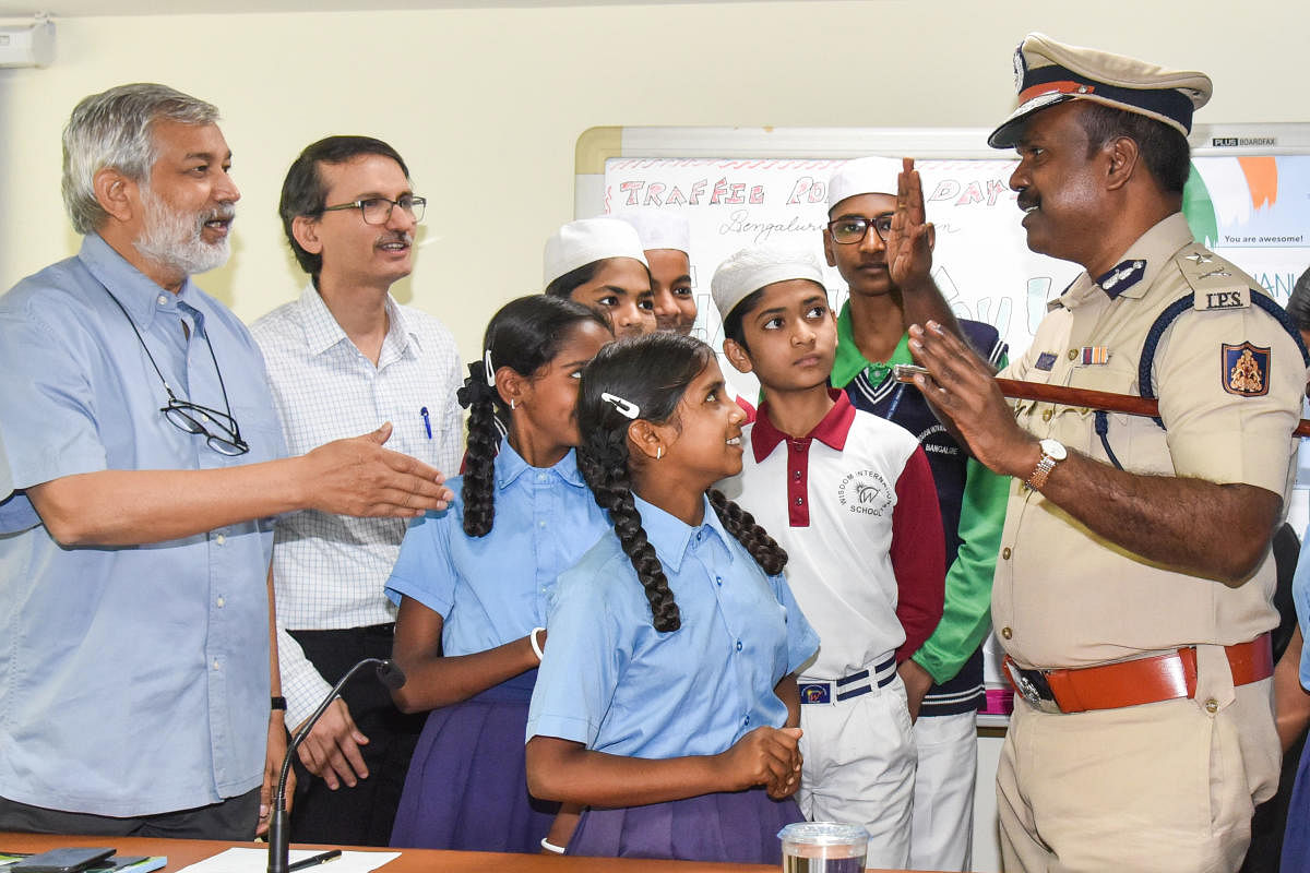 Harishekaran P, Additional Commissioner of Police (Traffic) interacting with students at Traffic Police Day programme organised by CMCA at Traffic Management Centre in Bengaluru on Monday, Ashish Patel, Director, CMCA, Ajai Kumar Singh, former DG and IGP