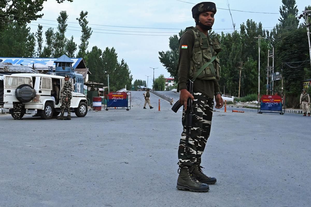 Security personnel stand guard a street during a lockdown in Srinagar on August 12, 2019. (AFP)