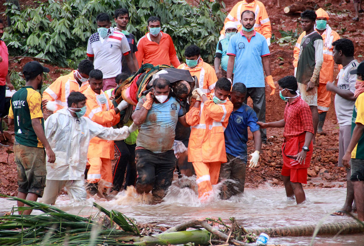 Rescuers carry the body of a victim after extracting it from the debris after a landslide caused by torrential monsoon rains in Kavalappara in Malappuram district in the southern state of Kerala, India, August 13, 2019. (REUTERS/Stringer)
