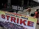 A couple crosses an empty taxi bay beside a strike notice at Calcutta airport during a strike in Calcutta, India, Monday. AP