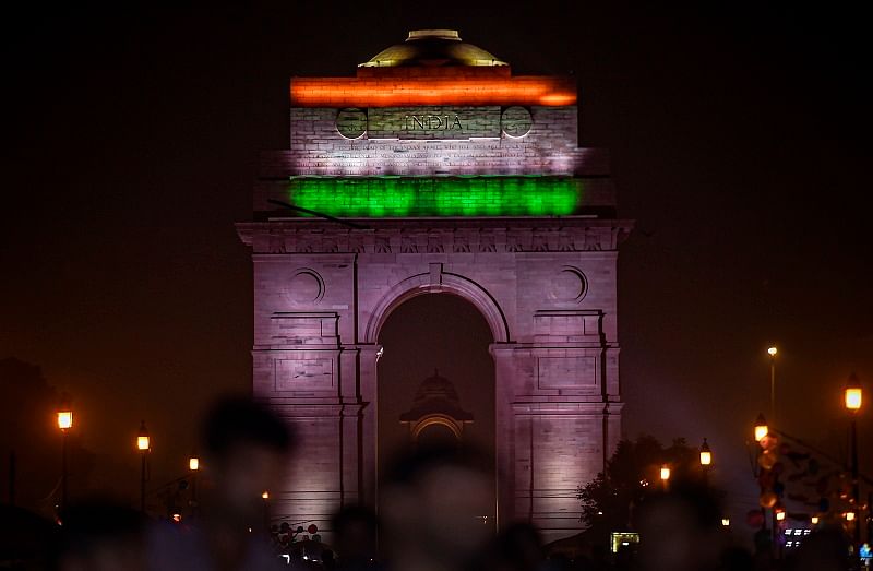 People gather near the India Gate adorned with the national flag colours in New Delhi on August 14, 2019, on the eve of the country's 73rd anniversary of independence from British rule. (Photo by Jewel SAMAD / AFP)