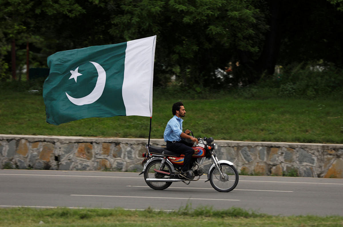 A man rides on a motorbike with a national flag ahead of country's Independence Day in Islamabad. Reuters photo