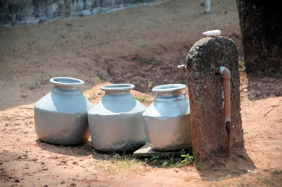 Woman carrying drinking water at Swasthi Road, Shantinagar in Bengaluru. DH Photo by S K Dinesh