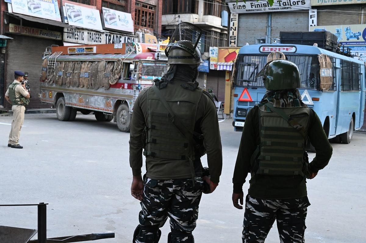 Security personnel stand guard on a street during a lockdown in Srinagar on August 12, 2019. - Indian troops clamped tight restrictions on mosques across Kashmir for Eid al-Adha festival, fearing anti-government protests over the stripping of the Muslim-m