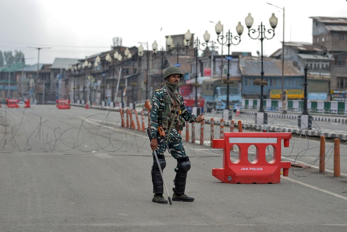 A security personnel stands guard along a street during a lockdown in Srinagar. AFP photo