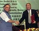 Indian Environment Minister Jairam Ramesh shakes hands with his Chinese counterpart Xie Zhenhua after signing an agreement in New Delhi. AP