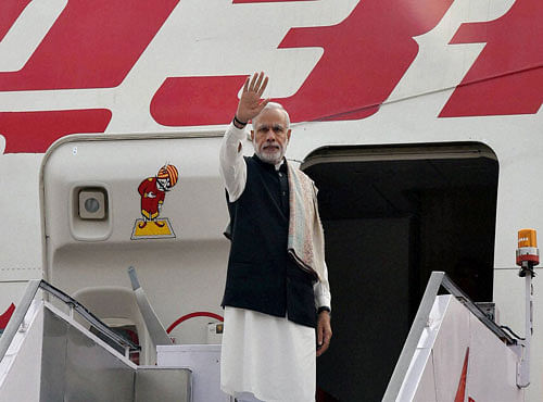 Prime Minister Narendra Modi waves before his departure for France to attend the Paris Climate Conference, at AFS Palam in New Delhi on Saturday. PTI Photo